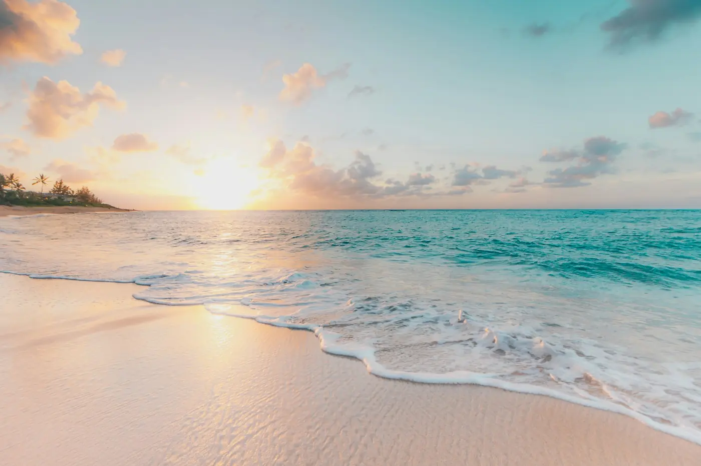 Family of four at a beach, one of the best places to travel with kids on a budget